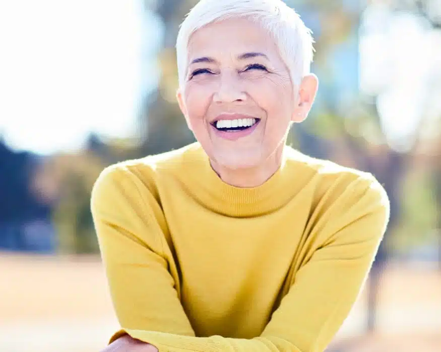mature woman showing off her confident smile thanks to dentistry in Wilmington, NC